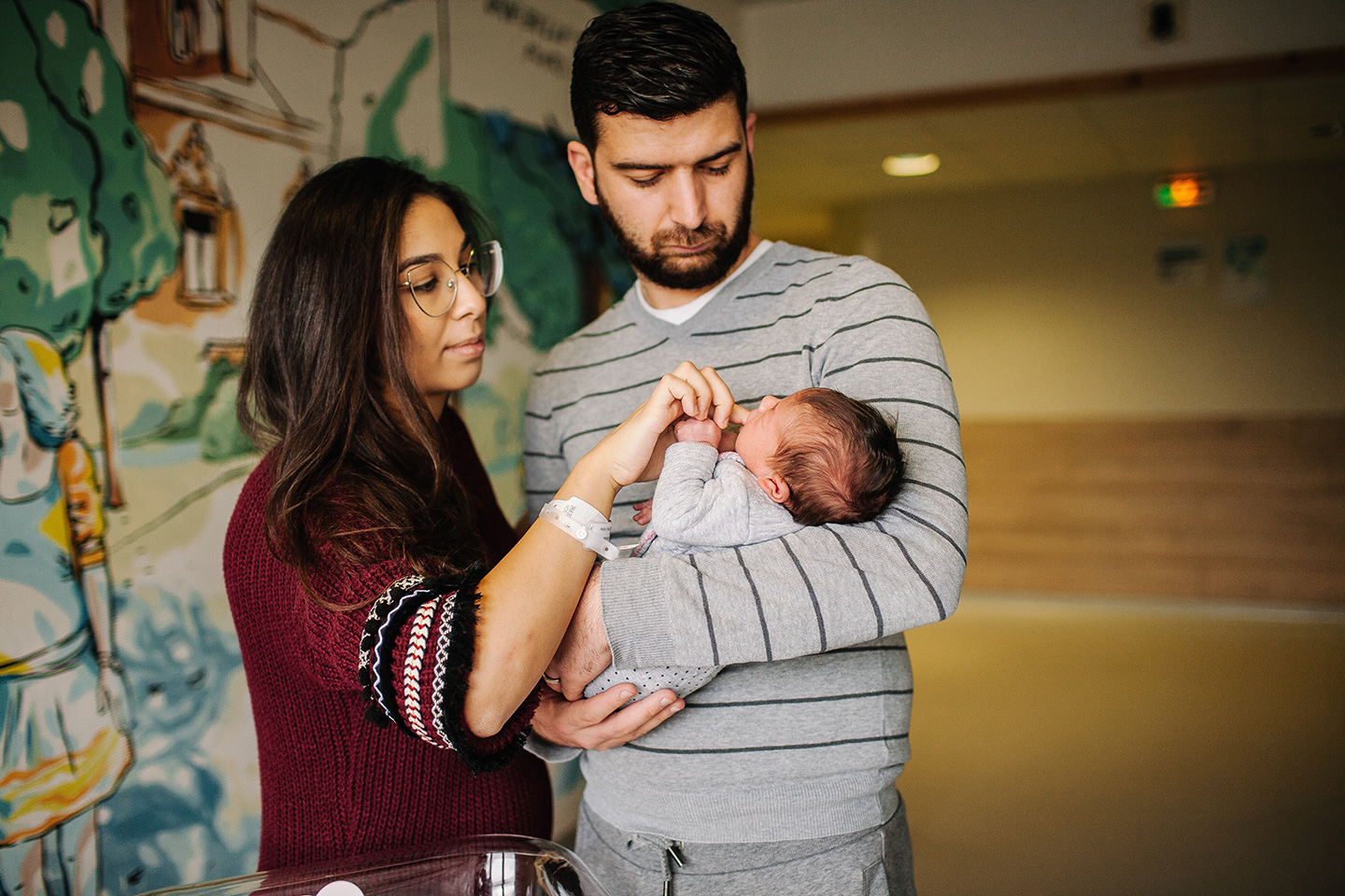 New parents holding their baby in a hospital
